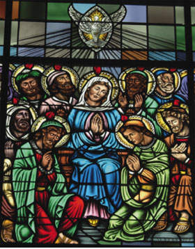 A stained glass window depicting the Saints receiving the Holy Spirit at Pentacost.